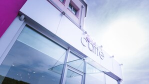 A building with a large glass entrance and a sign that reads "Café".