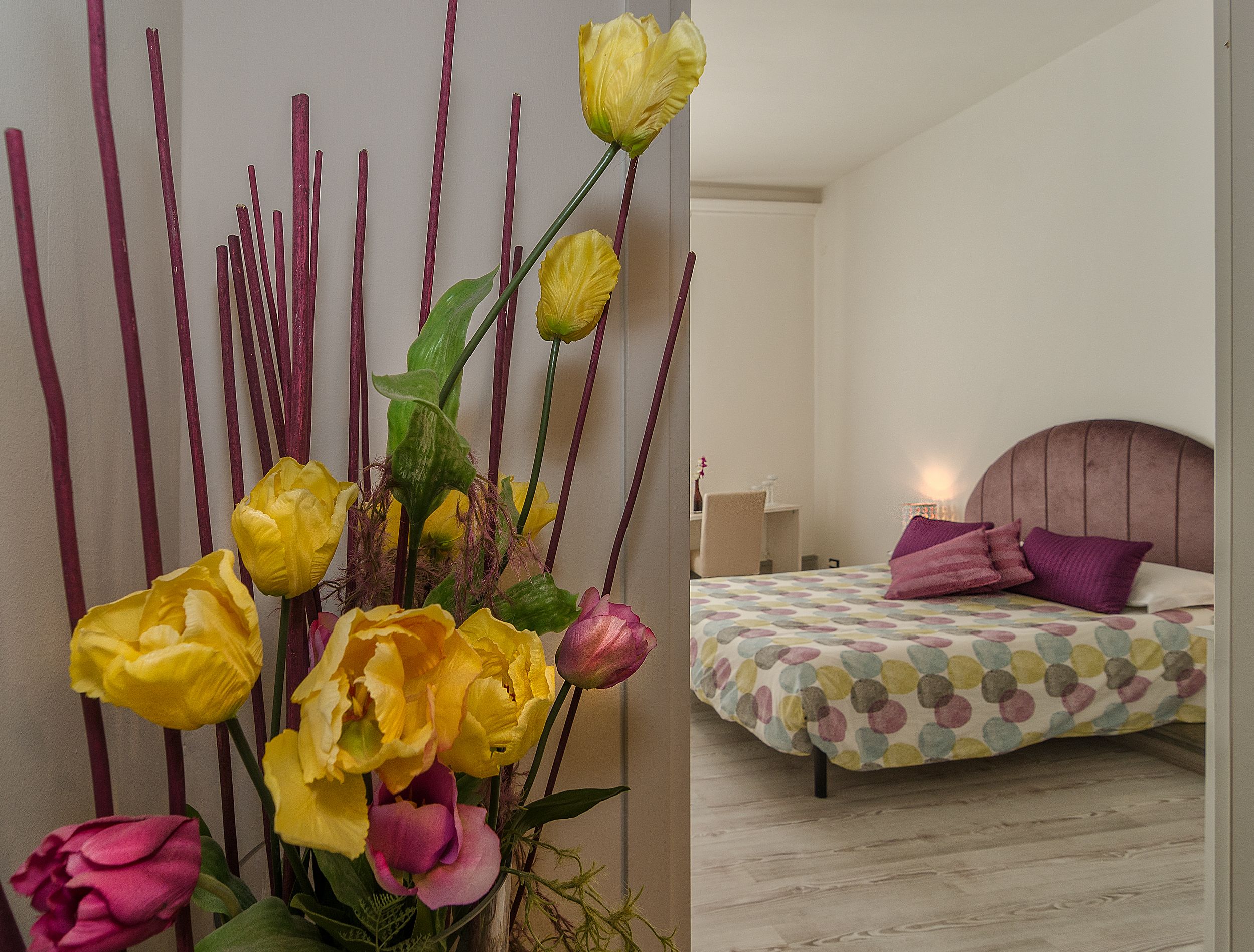A bedroom with a bed, pillows, and a nightstand.