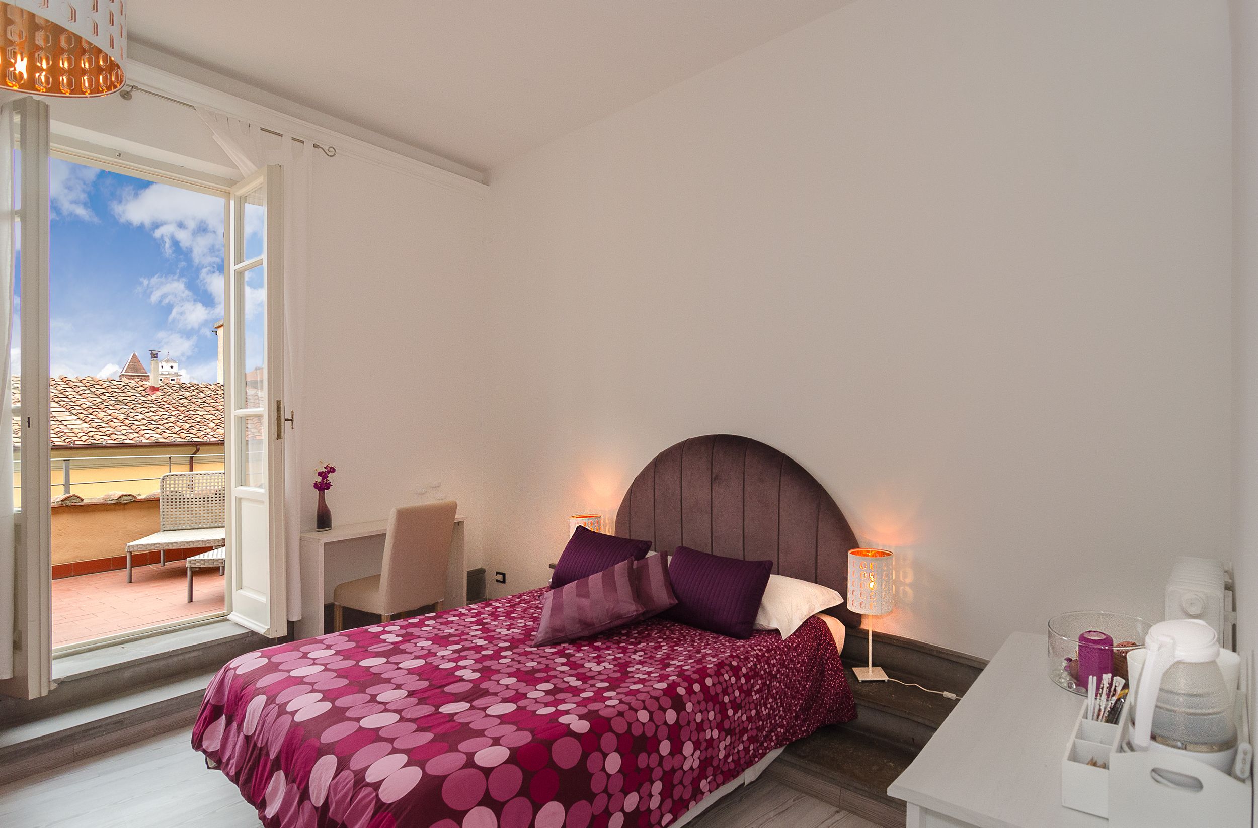 Une chambre à coucher avec un lit, un bureau, une chaise et une vue sur l’extérieur.