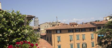 A building with a terracotta roof, a bell tower, and a sign for a restaurant.