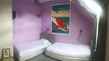 Ein Zimmer mit zwei Einzelbetten, einem Poster an der Wand und einem kleinen Schreibtisch.