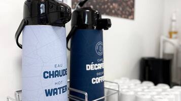 Two water bottles on a metal rack, one labeled 'EAU CHAUDE HOT WATER' and the other 'CAFE DÉCafé Deco Coffee'.