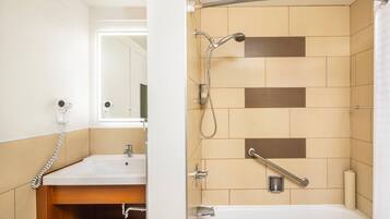 A bathroom with a shower, a sink, a mirror, and a towel rack.