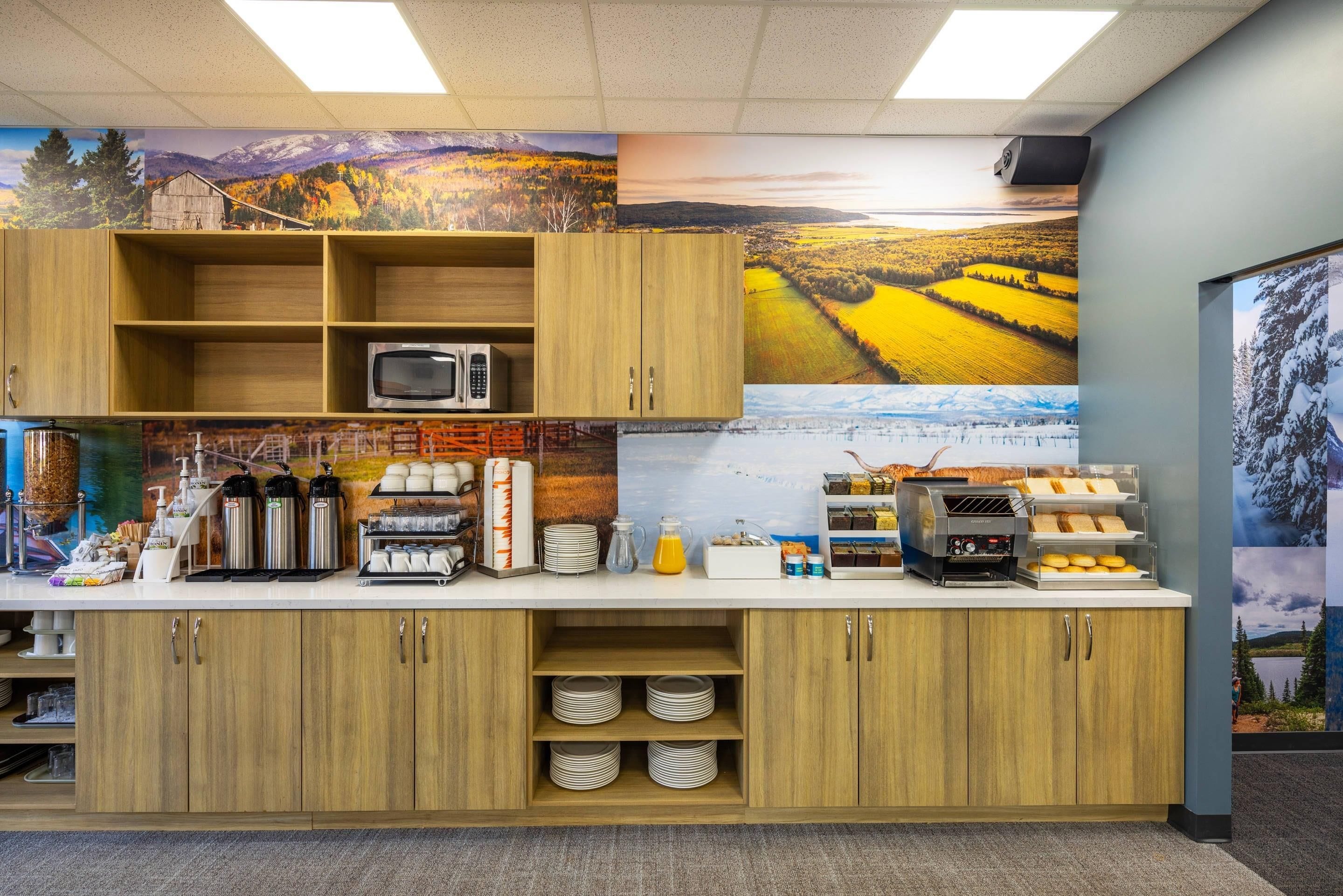 A kitchen area with wooden cabinets, a microwave, coffee makers, and a toaster.