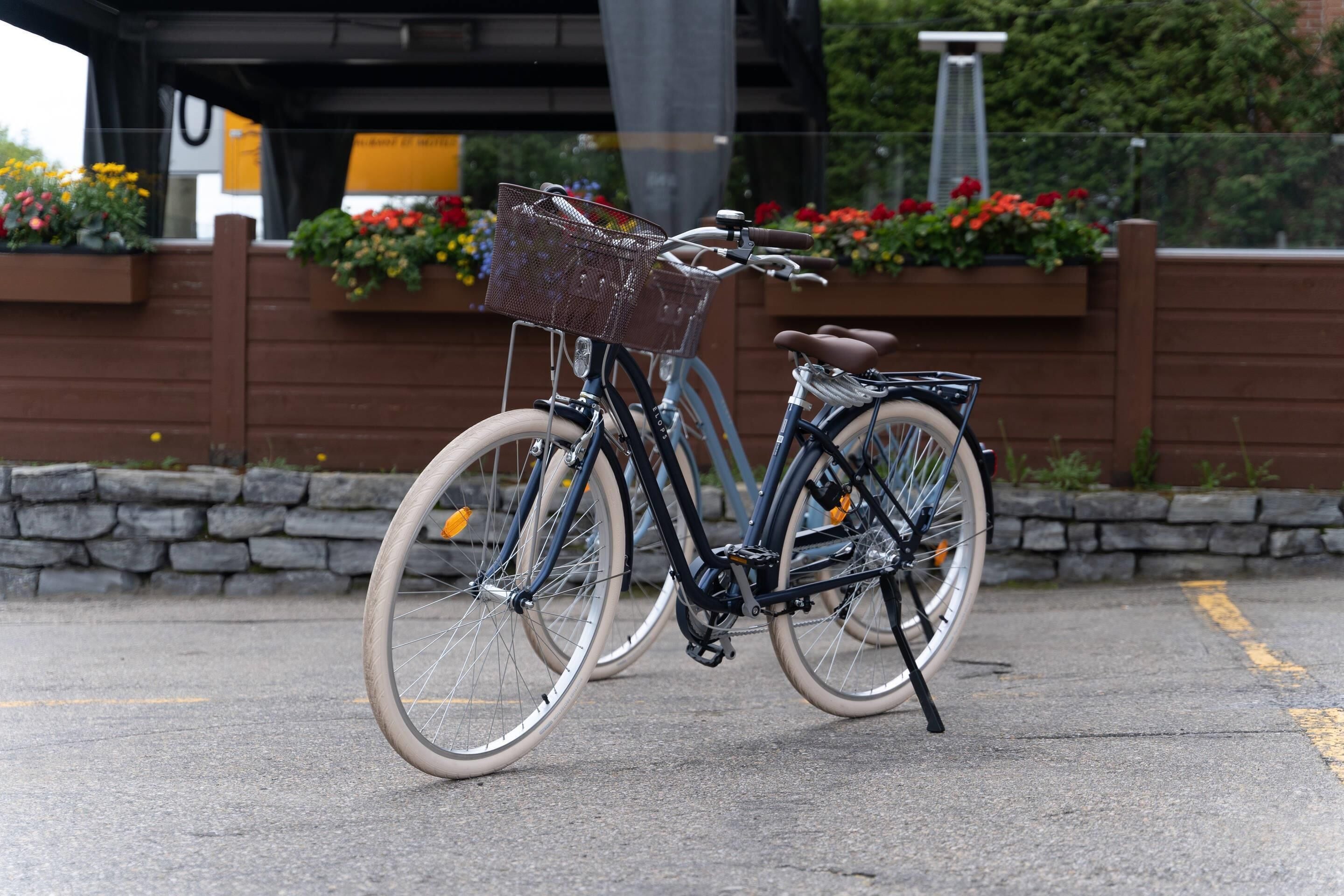 A bicycle parked on a paved surface with a basket attached to the front.