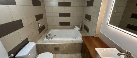 A bathroom with a bathtub, toilet, and sink.