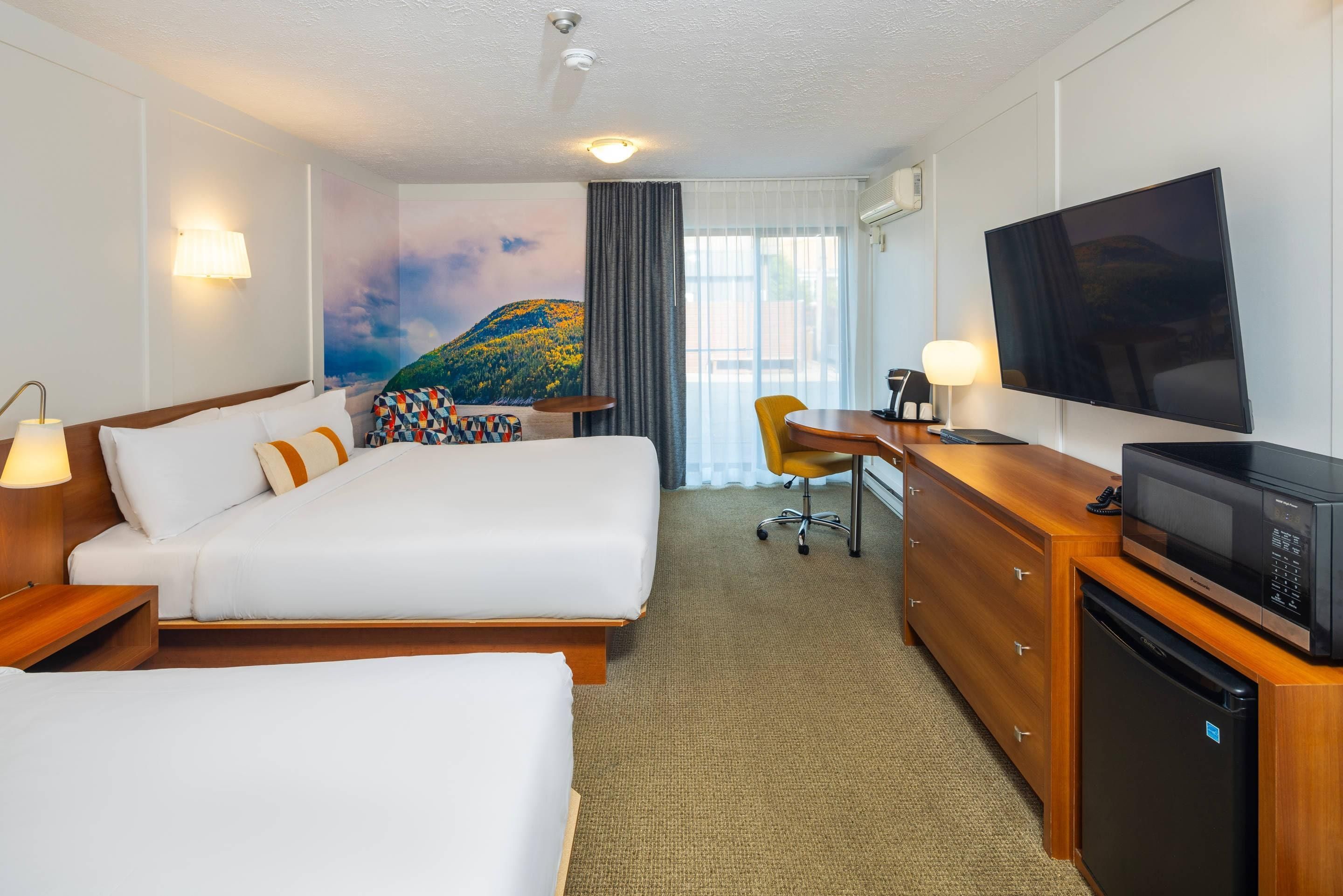 Een hotelkamer met een bed, bureau, televisie en magnetron.