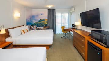 Een hotelkamer met een bed, bureau, televisie en magnetron.