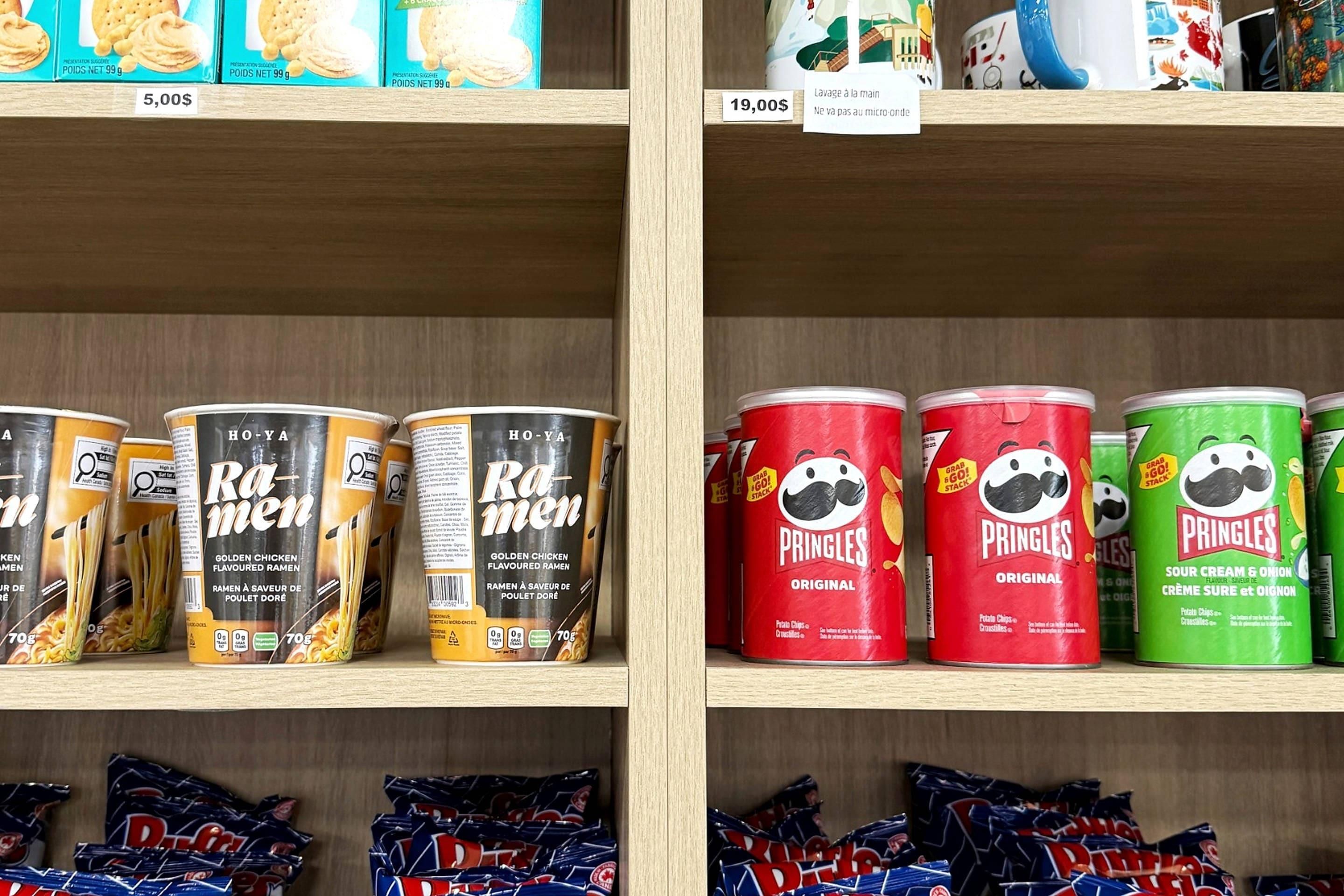 Shelves stocked with various food items including cans of ramen and pringles.