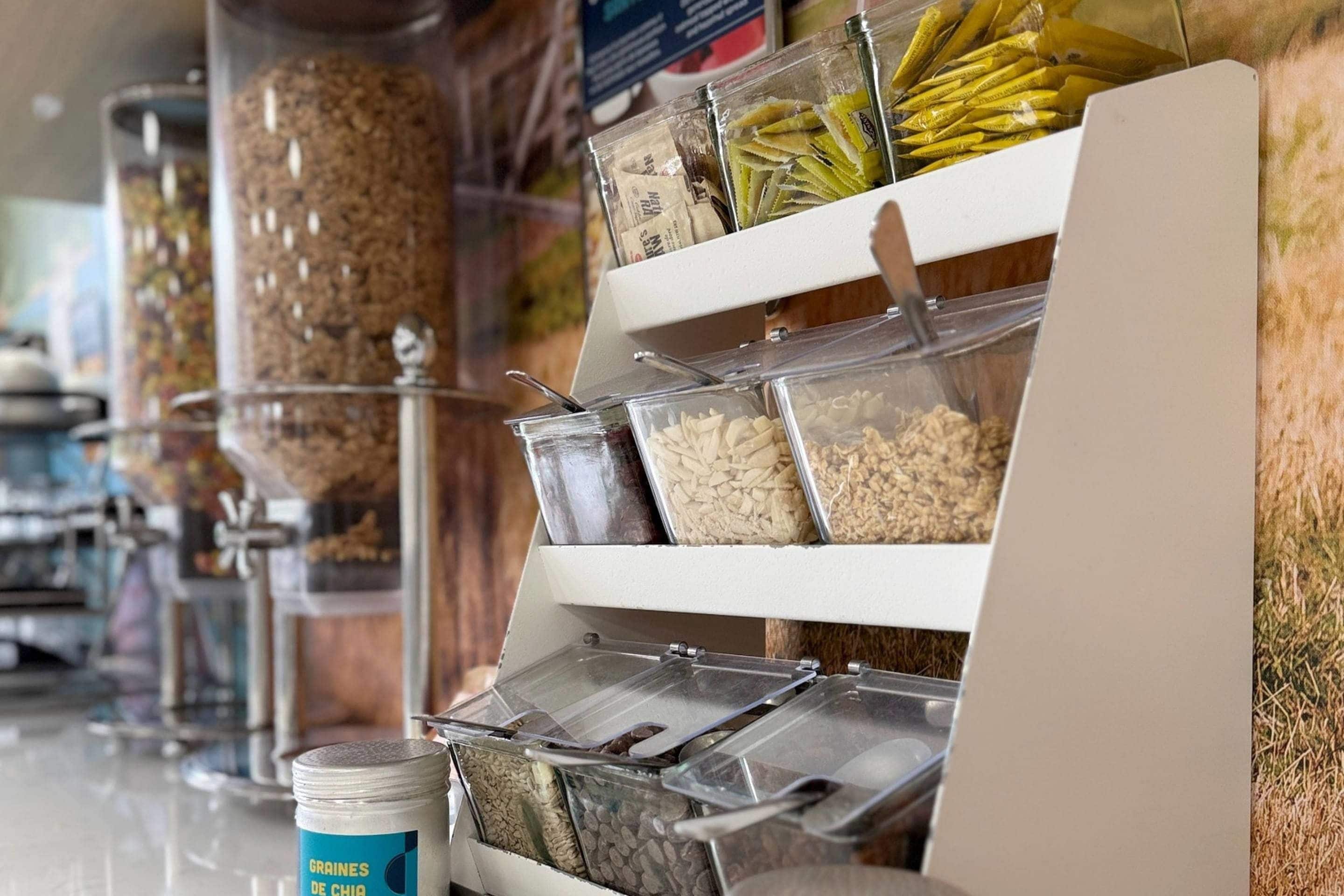 Een buffet met verschillende bakken vol granen en snacks.