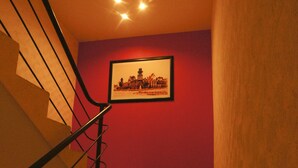 A staircase with a metal railing leading to a landing with a framed picture on the wall. - First Inn Hotel & Business (Texcoco de Mora)