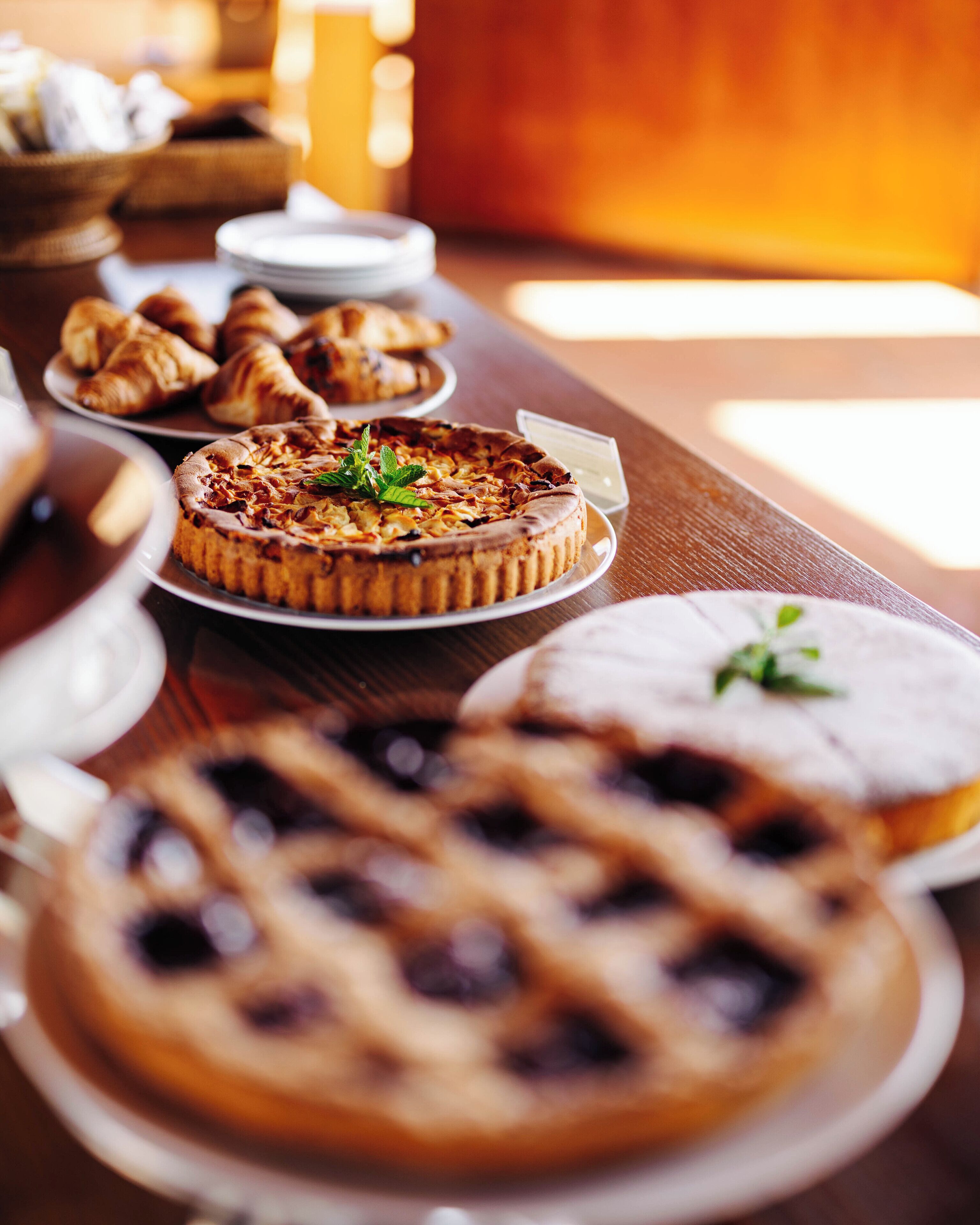 Variedad de postres sobre una mesa de madera, incluyendo una tartaleta, una tarta y varios pasteles.