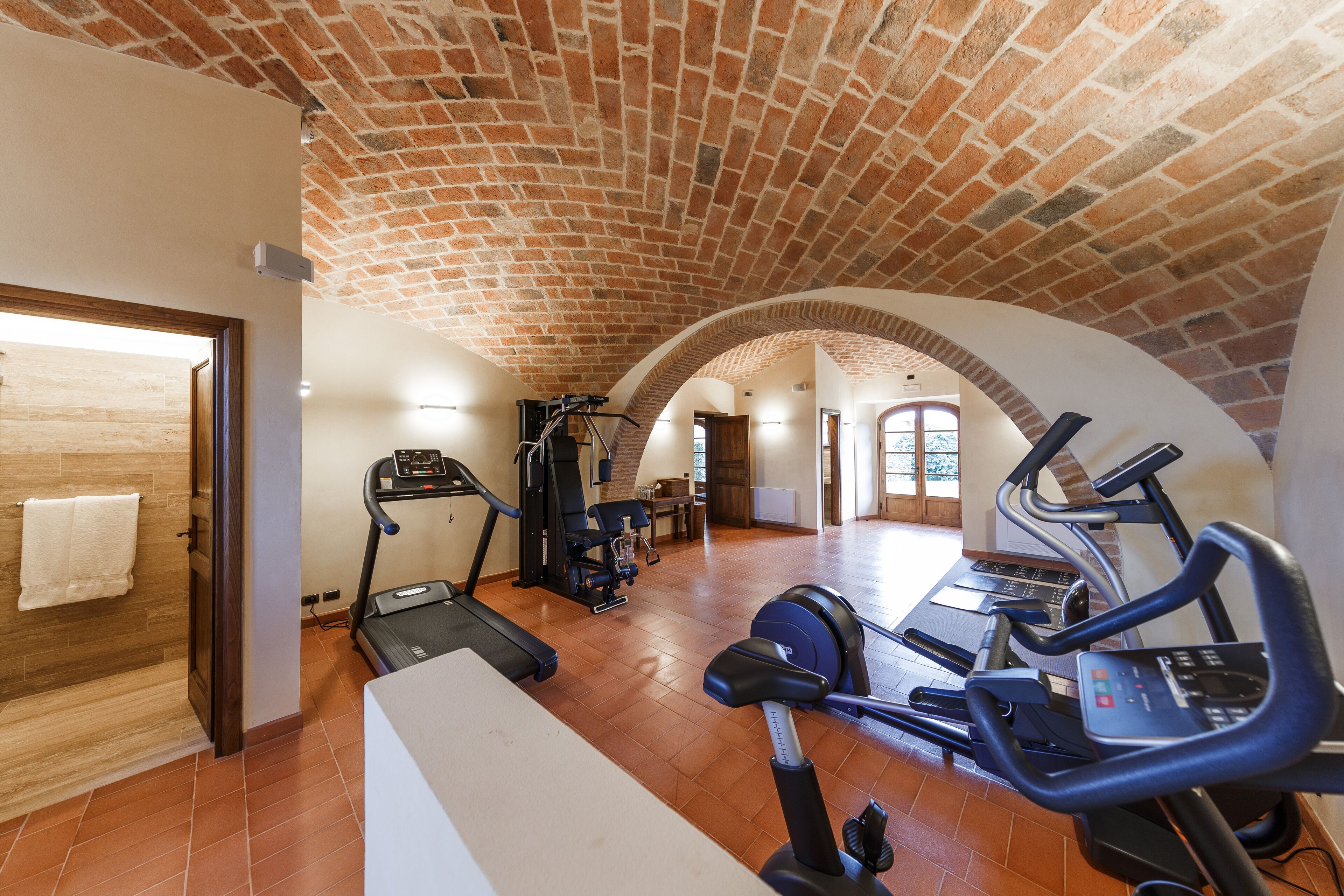 A spacious gym with treadmills, elliptical machines, and weight equipment.