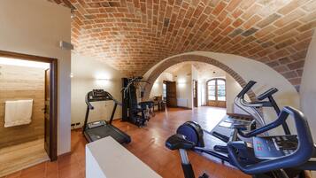 A spacious gym with treadmills, elliptical machines, and weight equipment.