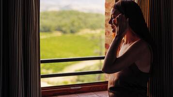 Una persona seduta vicino a una finestra con vista su un paesaggio verde.