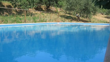 Una piscina al aire libre, sillones reclinables de piscina