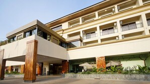 A multi-story hotel with a modern design, featuring balconies, outdoor seating, and a landscaped garden area. - Best Western Premier Garden Hotel Entebbe (Entebbe)
