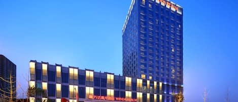 A multi-story hotel with a prominent sign reading 'Wanda Realm.'