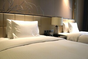 A hotel room with two beds, a wall-mounted lamp, and a telephone on the nightstand. - Wanda Realm Fuyang (Fuyang)