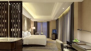 A hotel room with a bed, desk, chair, and a TV. - Wanda Realm Fuyang (Fuyang)