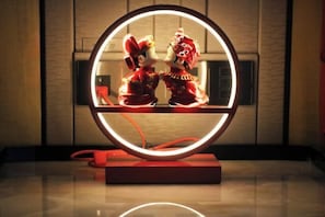 A circular mirror with a red frame, reflecting two figures in traditional attire. - Wanda Realm Fuyang (Fuyang)
