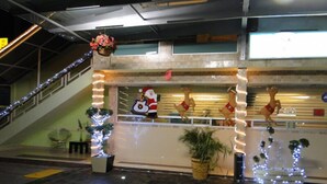 A lobby with a staircase, a reception desk, and Christmas decorations including a Santa Claus figure and reindeer. - Hotel Cuellar (Tula de Allende)