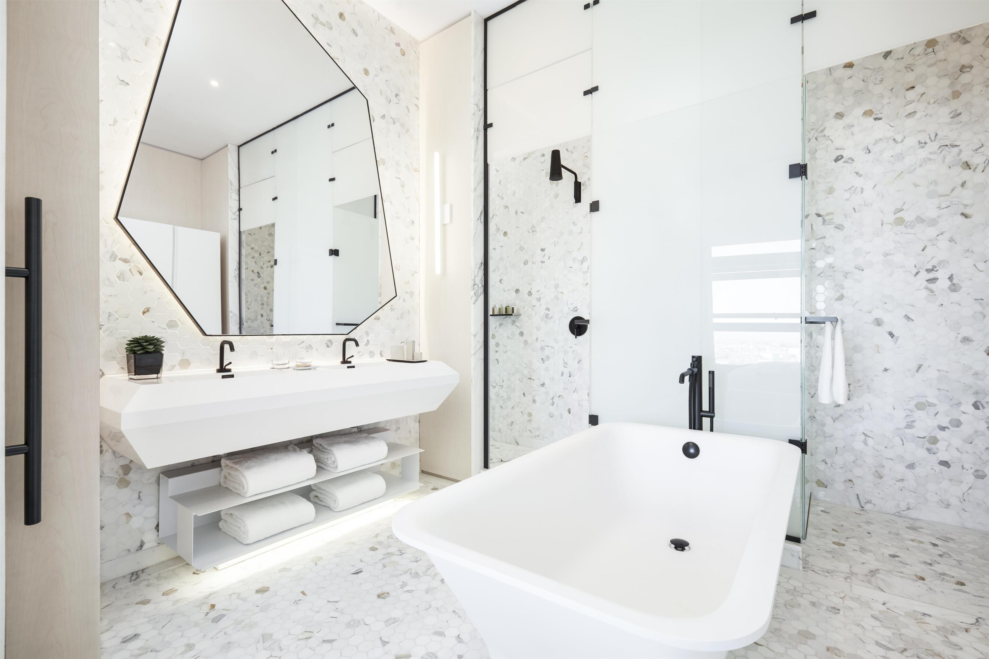 A modern bathroom with a freestanding bathtub, a large mirror, and a shower enclosure.