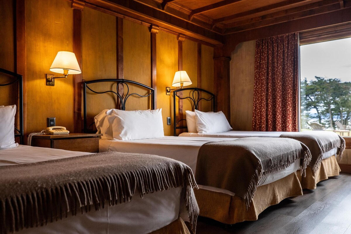 Habitación de hotel con dos camas, un teléfono y lámparas.