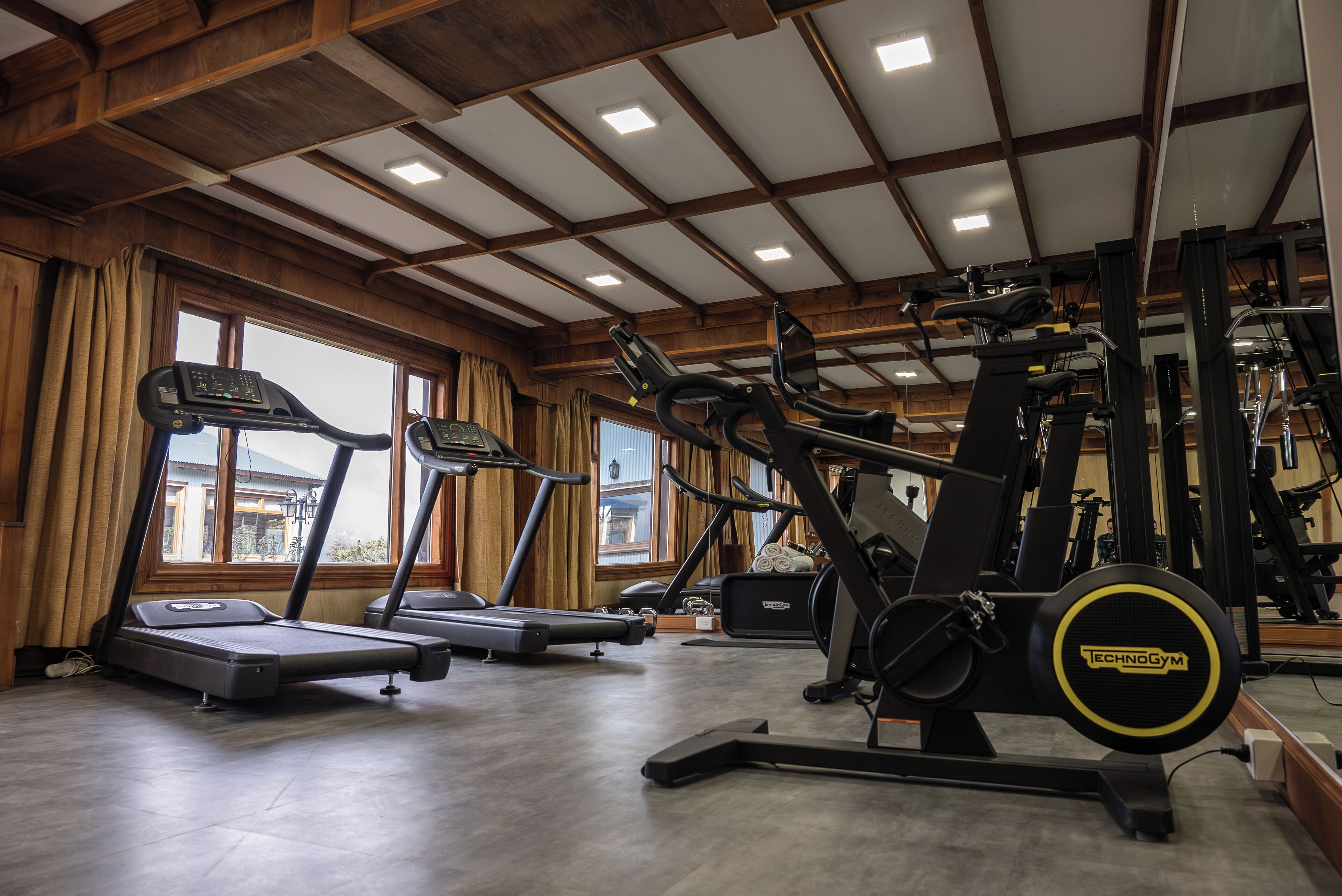 Un gimnasio con cintas de correr, elípticas y equipo de pesas.