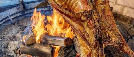 A large fire pit with logs and a fire burning.