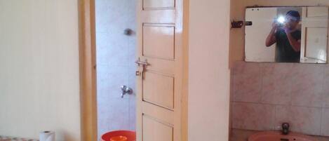 A bathroom with a sink, mirror, and toilet.