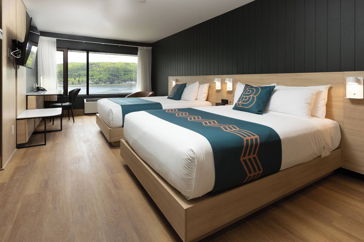 Ein modernes Hotelzimmer mit einem großen Bett, einem Schreibtisch und Blick ins Freie.