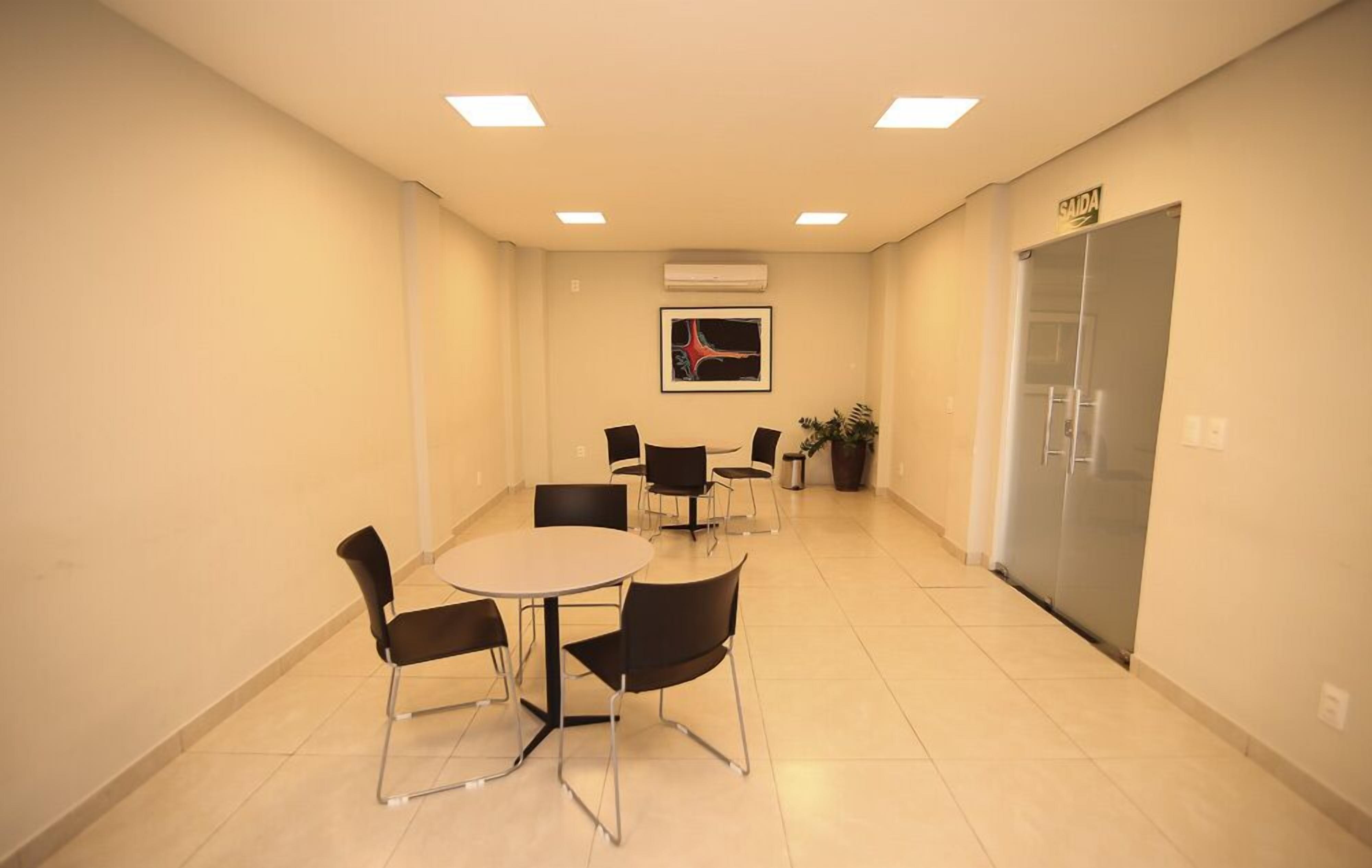 A conference room with a round table and six chairs, an air conditioning unit, and a door labeled "SAIDA".