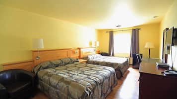 A hotel room with two beds, a desk, a chair, and a TV.