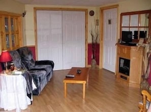 Ein Wohnzimmer mit einer Couch, einem Couchtisch, einem Fernseher und einem Kamin.
