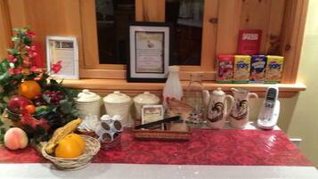 A kitchen counter with various items including a fruit bowl, jars, a bottle, and a phone.
