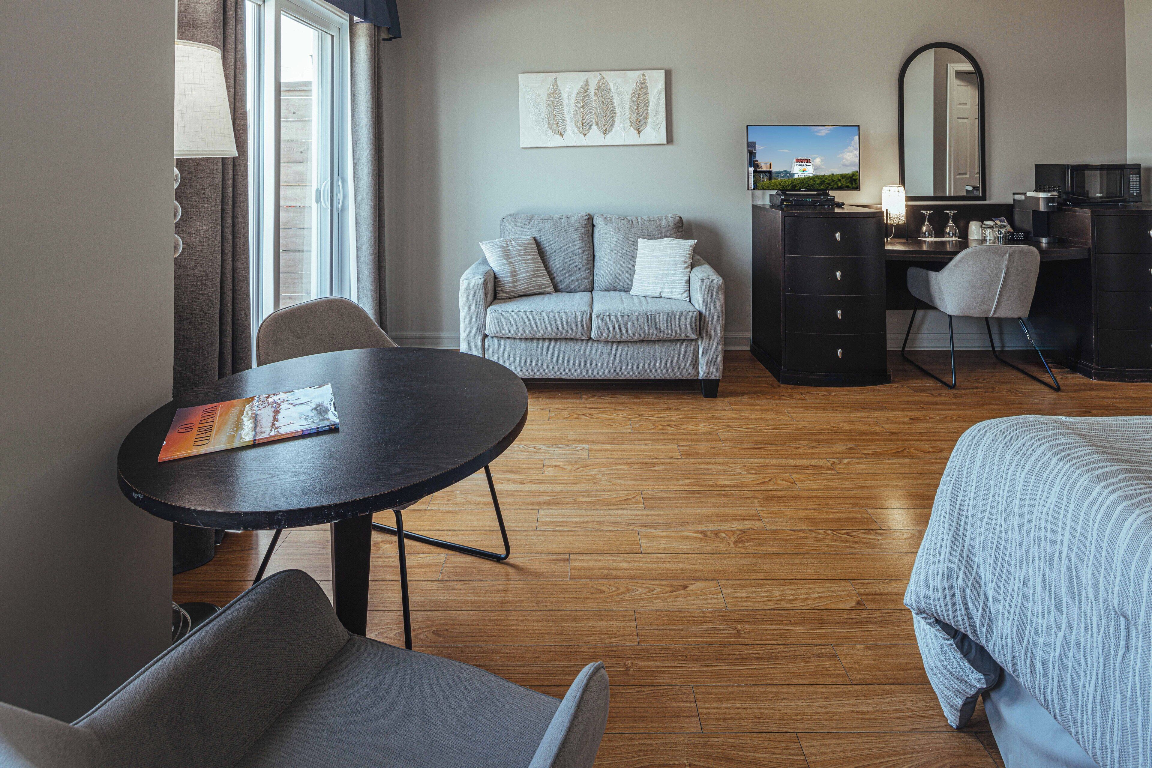 Habitación de hotel con sofá, escritorio, silla, cama y televisión.