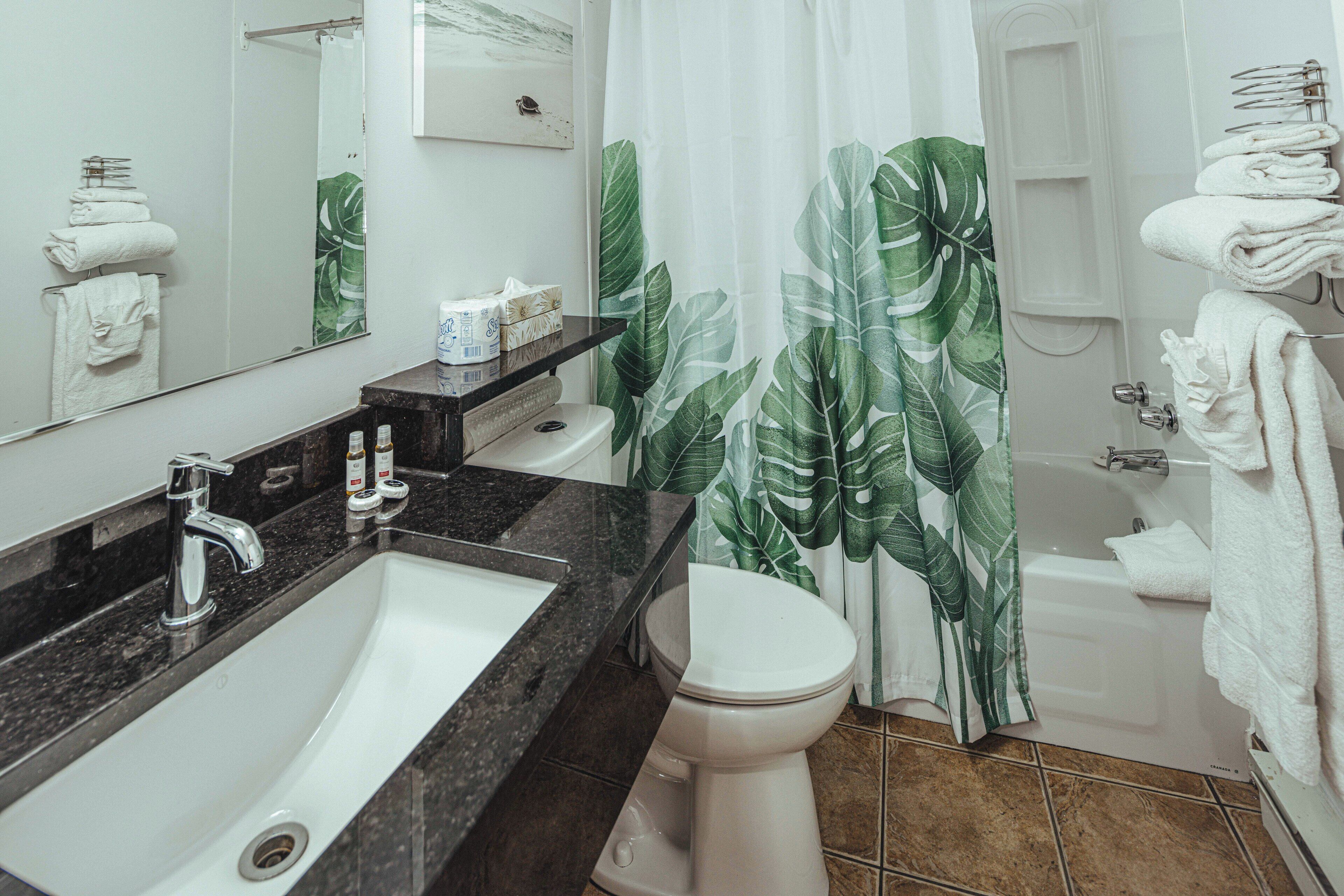 Ein Badezimmer mit Waschbecken, Toilette und Badewanne.