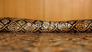 Cojín estampado con el texto "Hotel Atlant" y "ciencias 91".