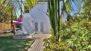 Ein modernes Haus mit Terrasse, weißen Wänden und einer Tür.