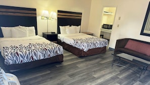 A hotel room with two beds, a sofa, a small table, a microwave, and a mirror. - Magnuson Hotel Sierra Vista (Sierra Vista)