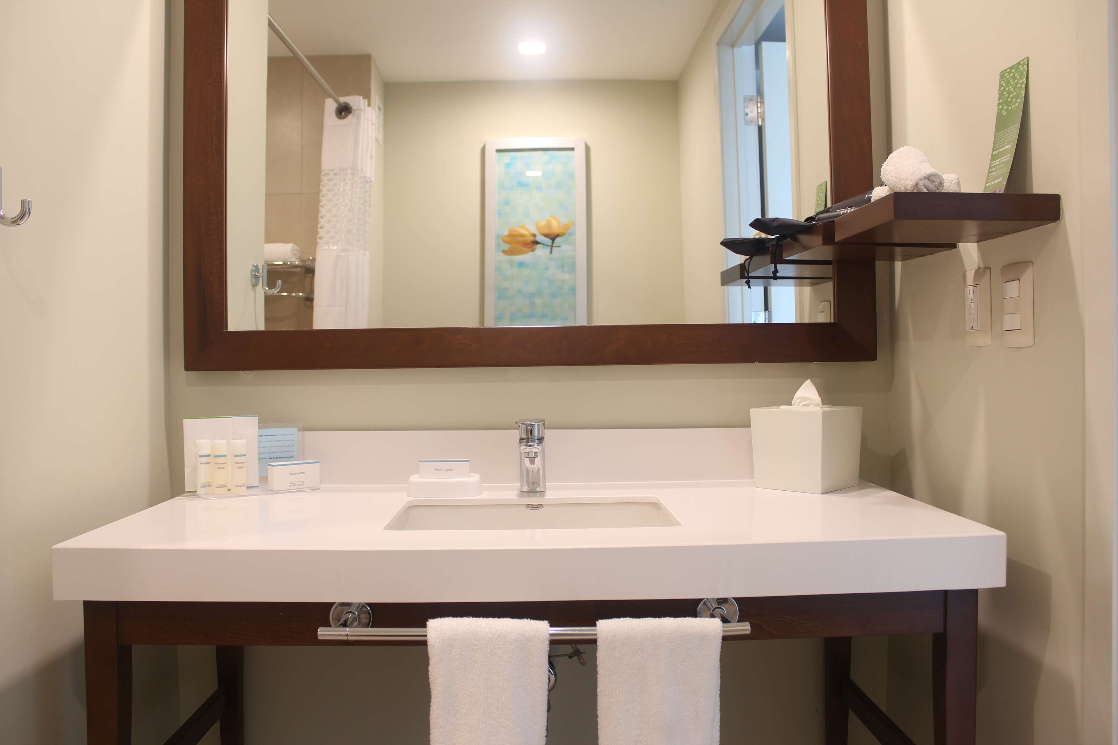 Une salle de bain avec un lavabo blanc, un miroir et un porte-serviettes.