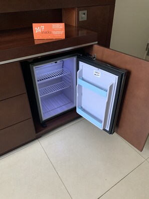 A compact refrigerator with a 24/7 snack service sign above it. - Hampton Inn by Hilton Villahermosa (Villahermosa)