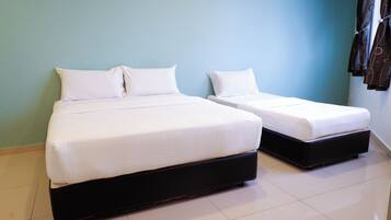 Two beds with white linens in a room with light blue walls and a tiled floor.