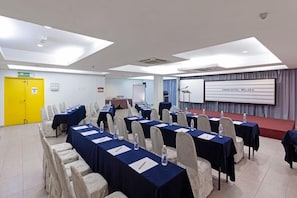 A conference room with tables, chairs, a podium, and a screen displaying 'KINGS HOTEL MELAKA'. - Kings Hotel Melaka (Malacca City)