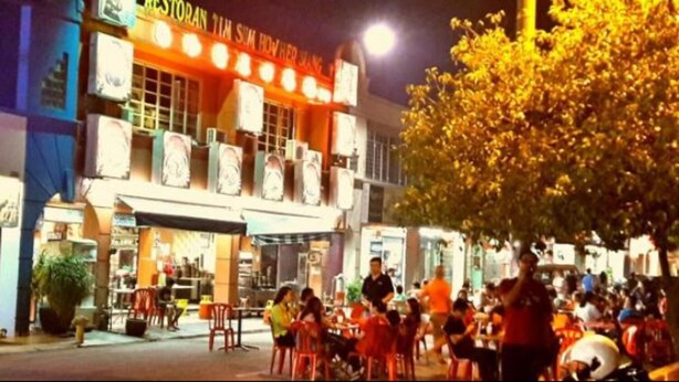 Un ristorante con posti a sedere all'aperto e molti avventori.