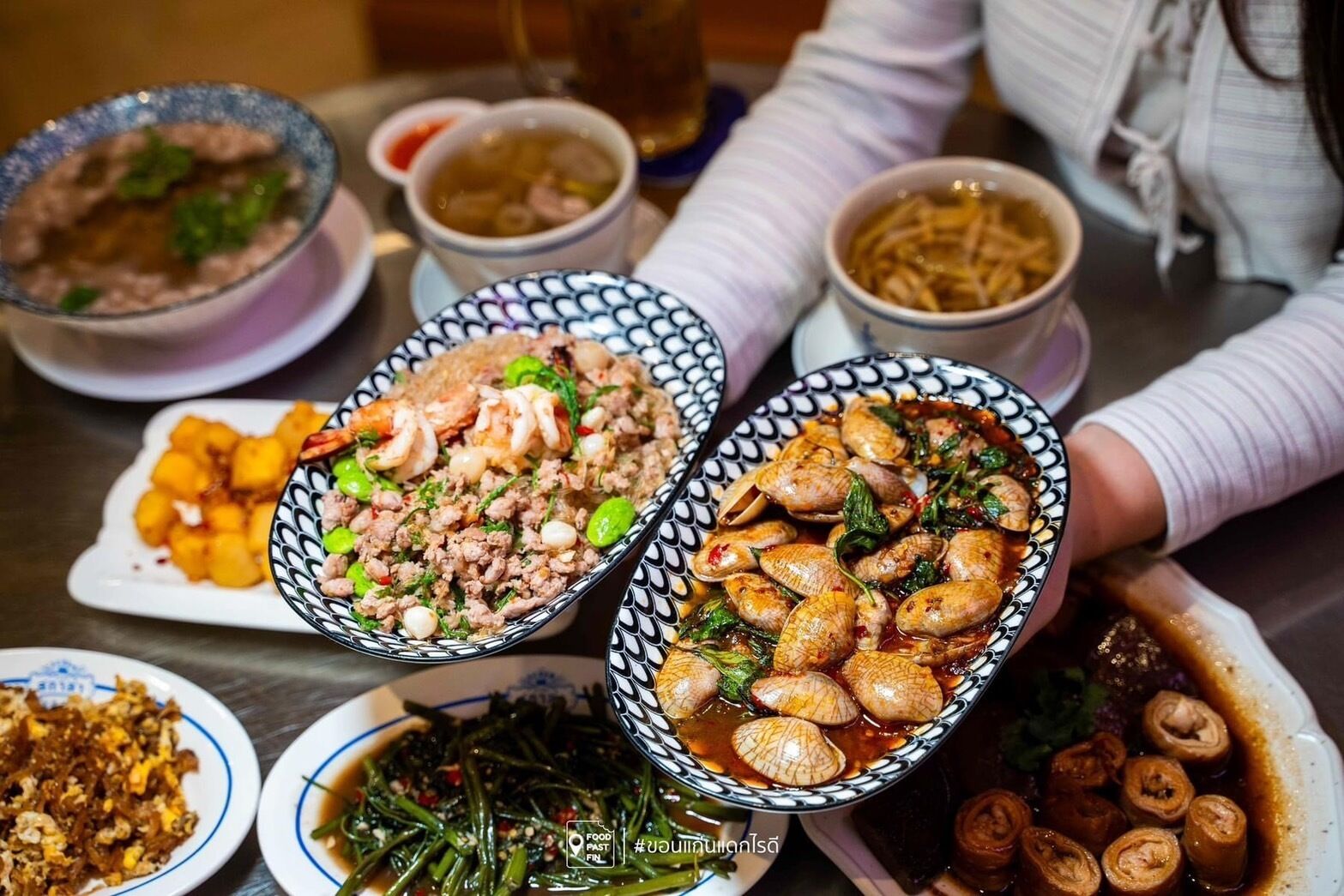 Una mesa con diversos platos, incluyendo mariscos y verduras, lo que sugiere un ambiente para comer.