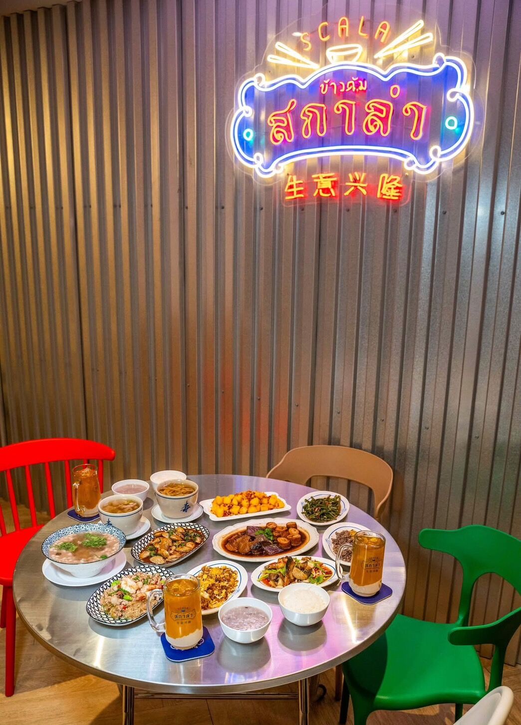 A restaurant with a neon sign and a variety of dishes on a round table.