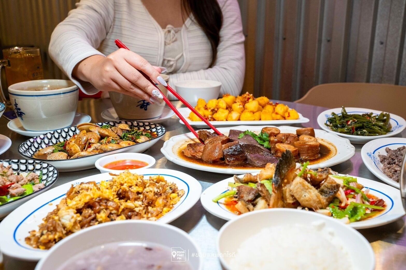 Ein Tisch mit verschiedenen Gerichten, darunter Reis, Fleisch und Gemüse, was auf eine Mahlzeit hindeutet.