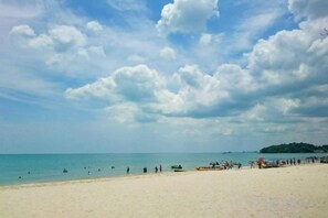 A beach with a sandy shore, calm sea, and a distant island. - Klana Beach Resort Port Dickson (Port Dickson)